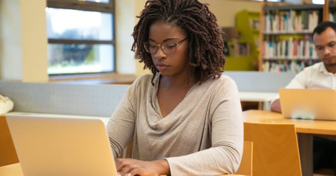 Two-people-working-on-laptops-in-library
